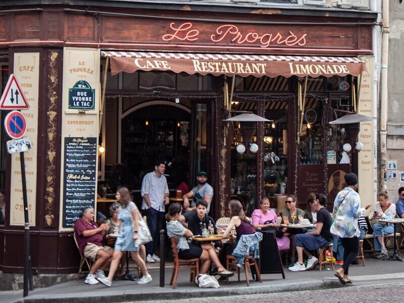 a group of people sitting outside of a restaurant