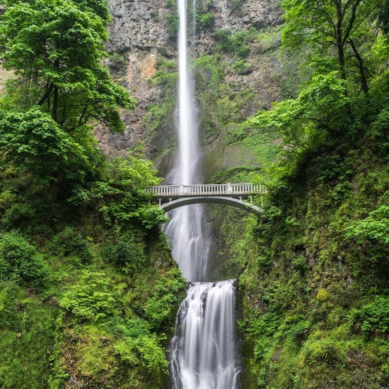gray concrete bridge and waterfalls during daytime