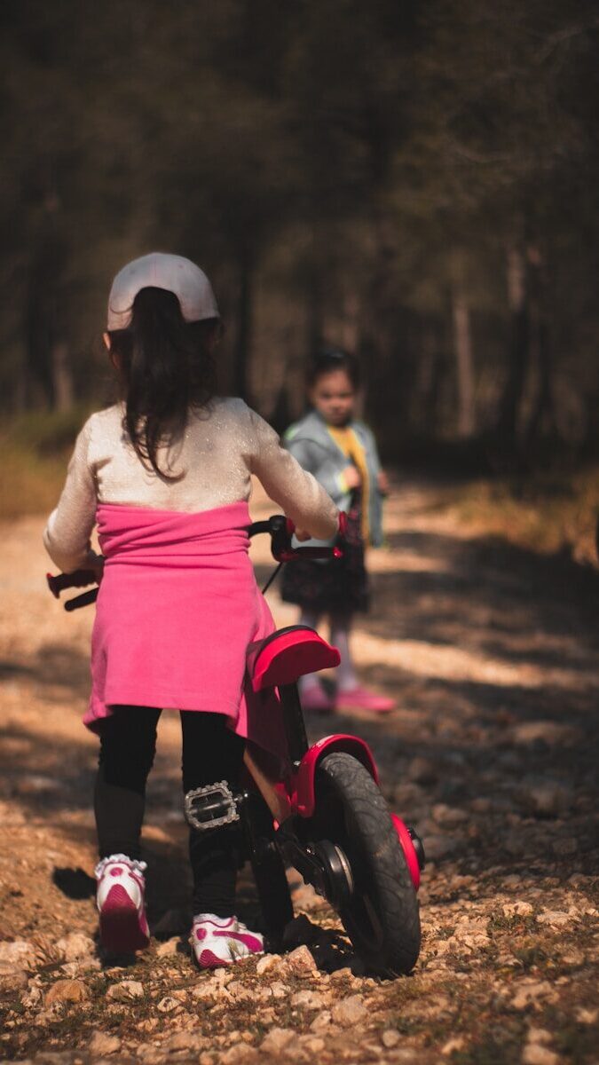 girl in pink dress riding on pink and black motorcycle during daytime