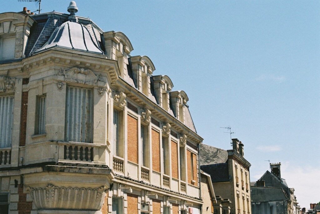 Ornate old building with dormer windows under blue sky