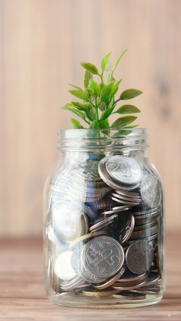 a glass jar filled with coins and a plant
