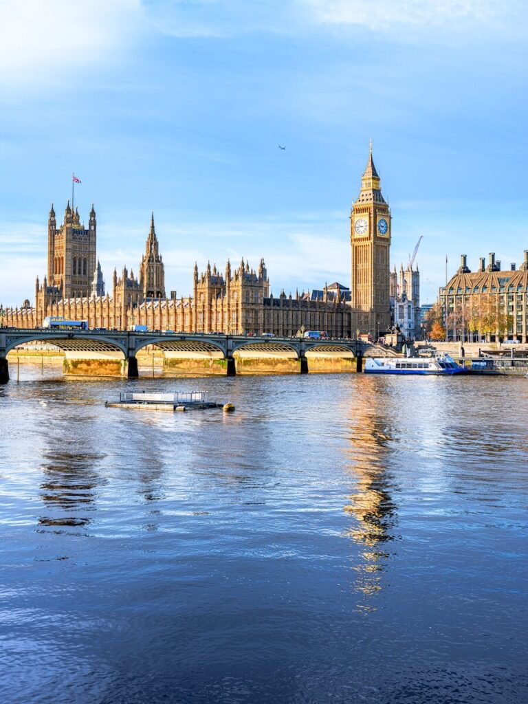 Big ben and parliament building reflected in the thames river.