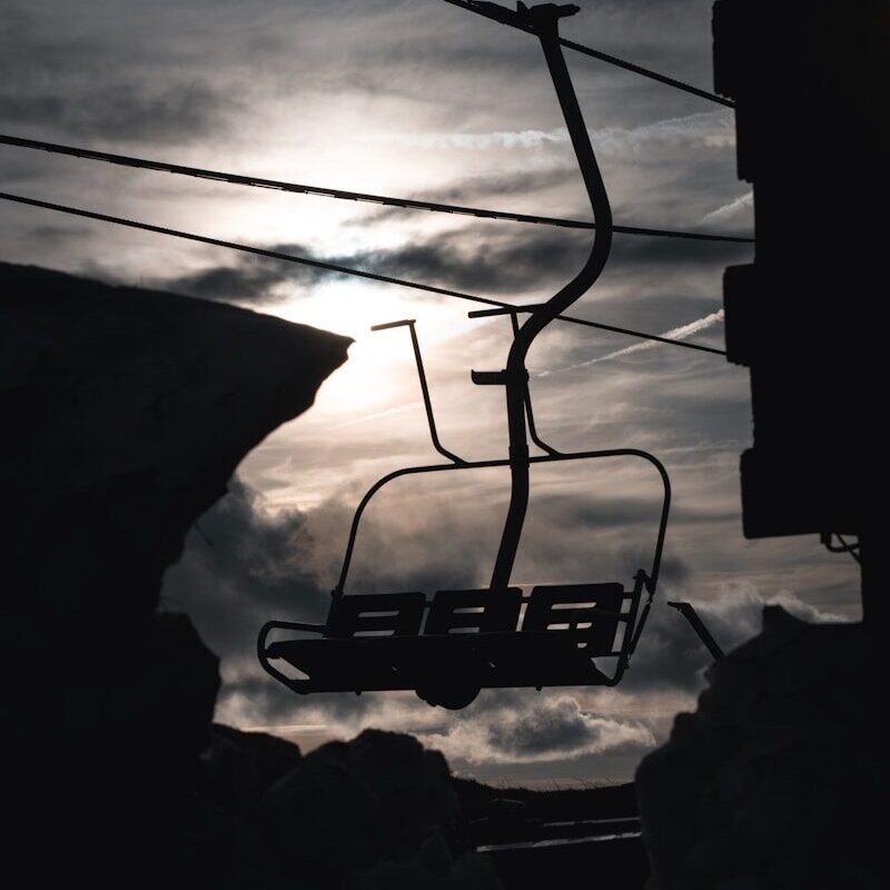 a ski lift with a sky background and clouds