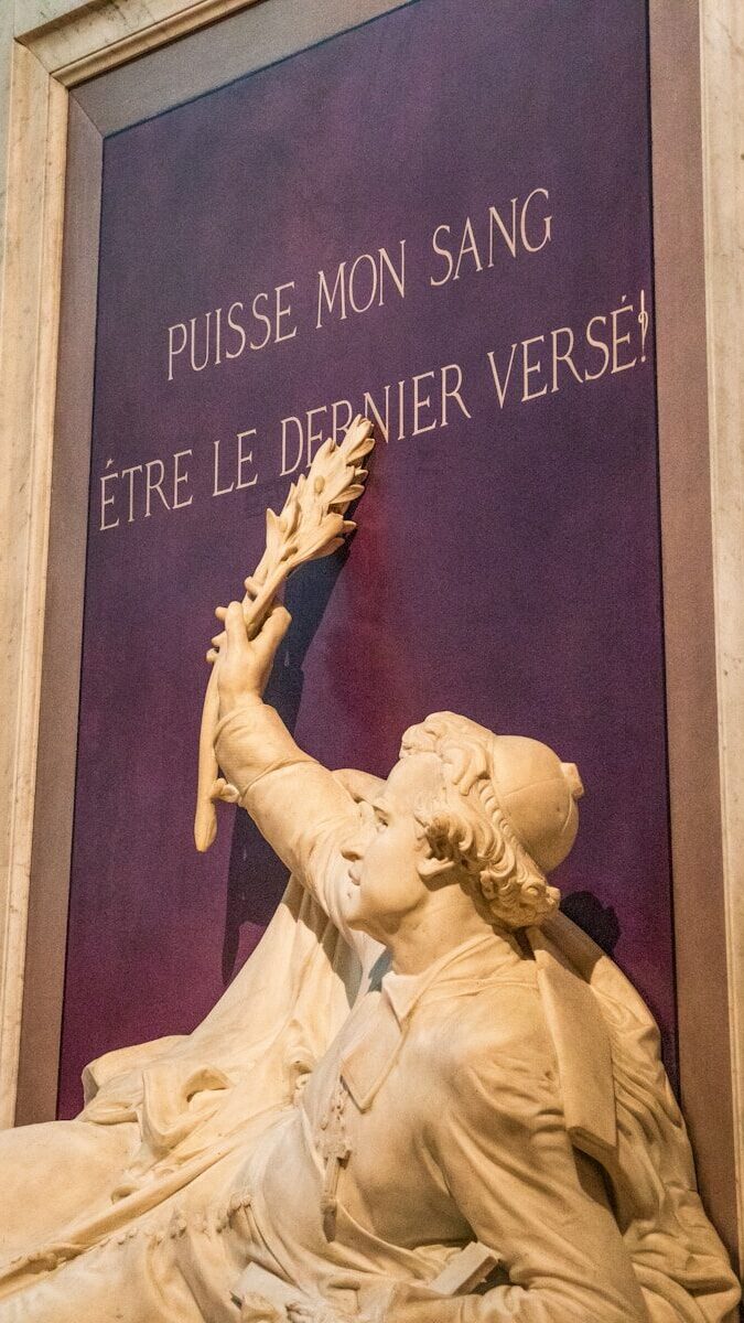 Marble sculpture with french inscription on a wall.