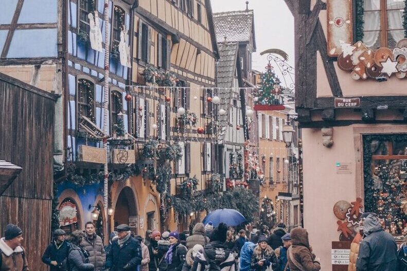 a group of people walking down a cobblestone street