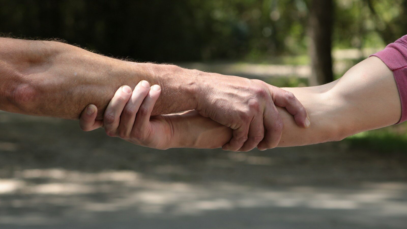 a close up of two people holding hands