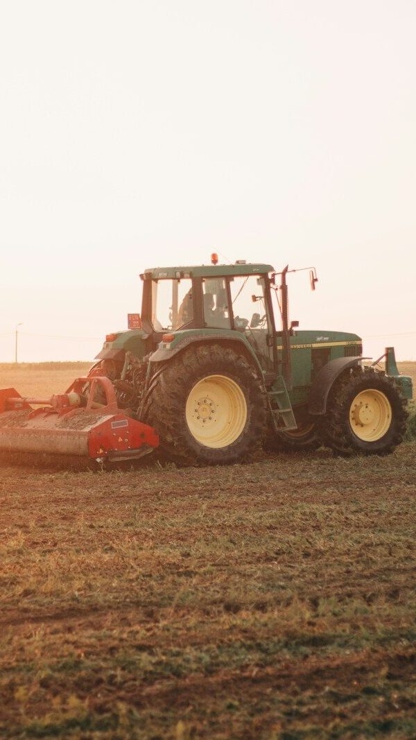 red tractor on brown field during daytime